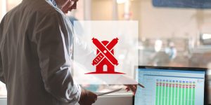 Two employees in lab coats discussing in front of a screen displaying data